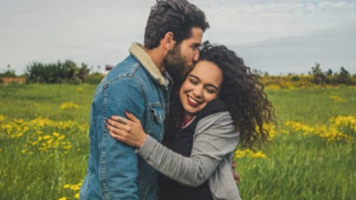 A couple embraces in a field of flowers