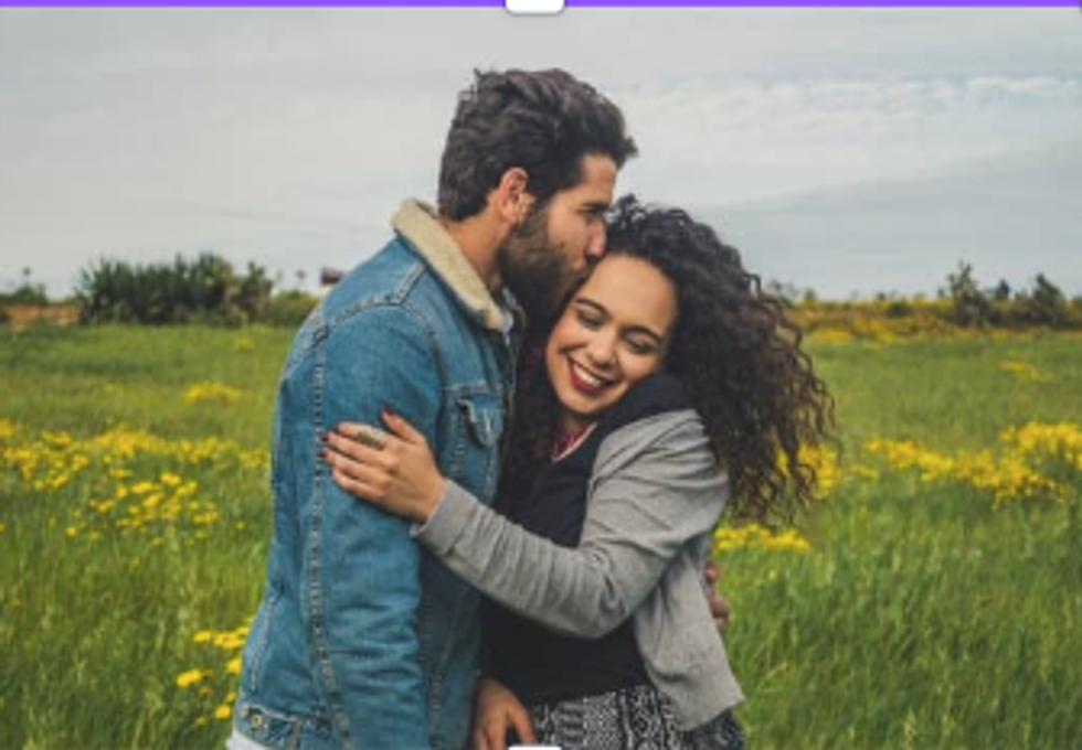 A couple embraces in a field of flowers