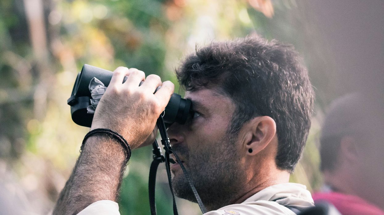 A man looks through binoculars