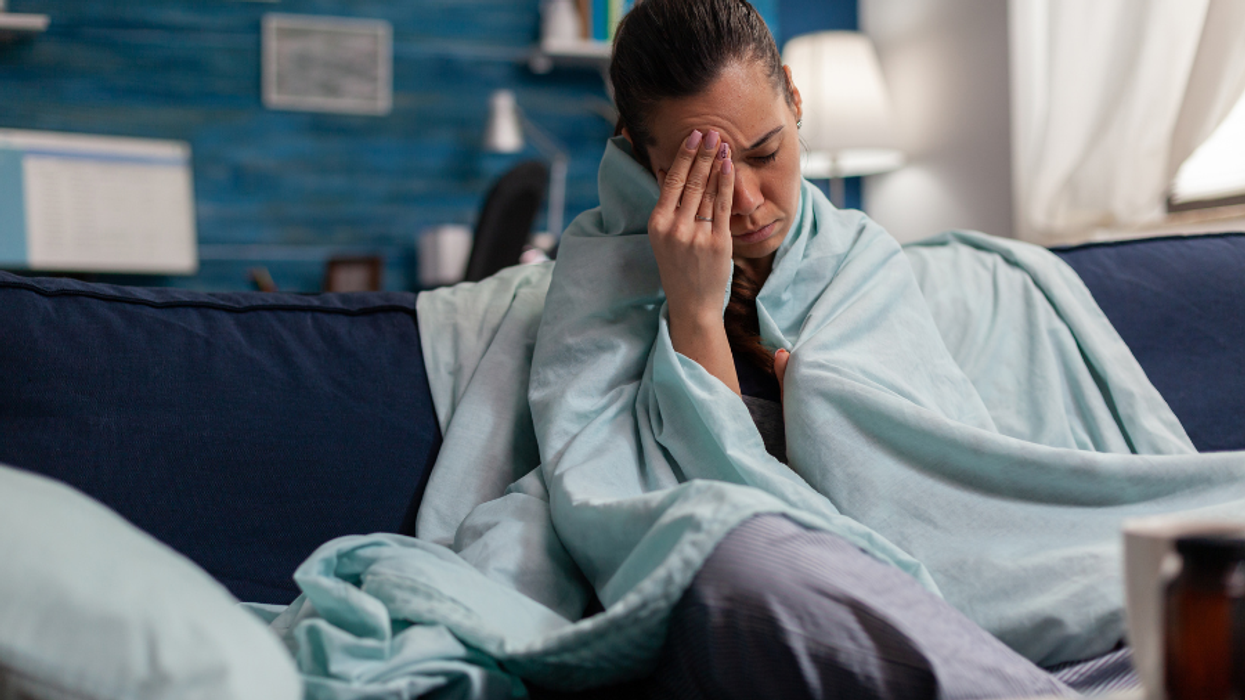 A sick person sitting on their couch