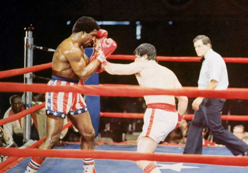 American actor Sylvester Stallone, as Rocky Balboa, punches American actor Carl Weathers, during a boxing match in a still from the film, 'Rocky.' (Image Source: Photo by Hulton Archive/Getty Images)