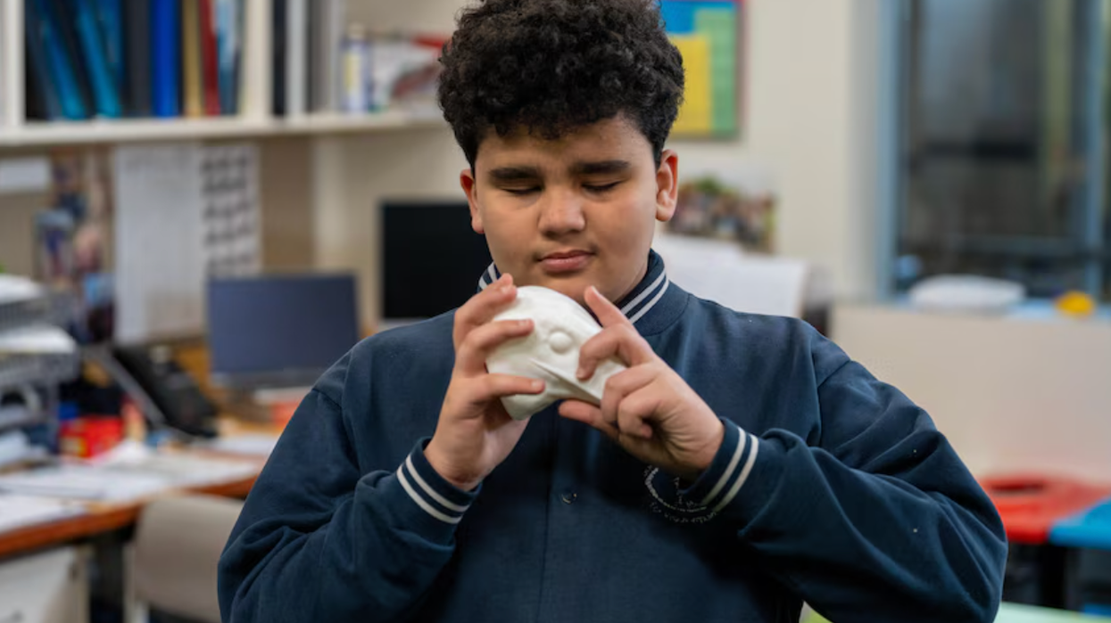 Blind student holding a model of a hawk's head