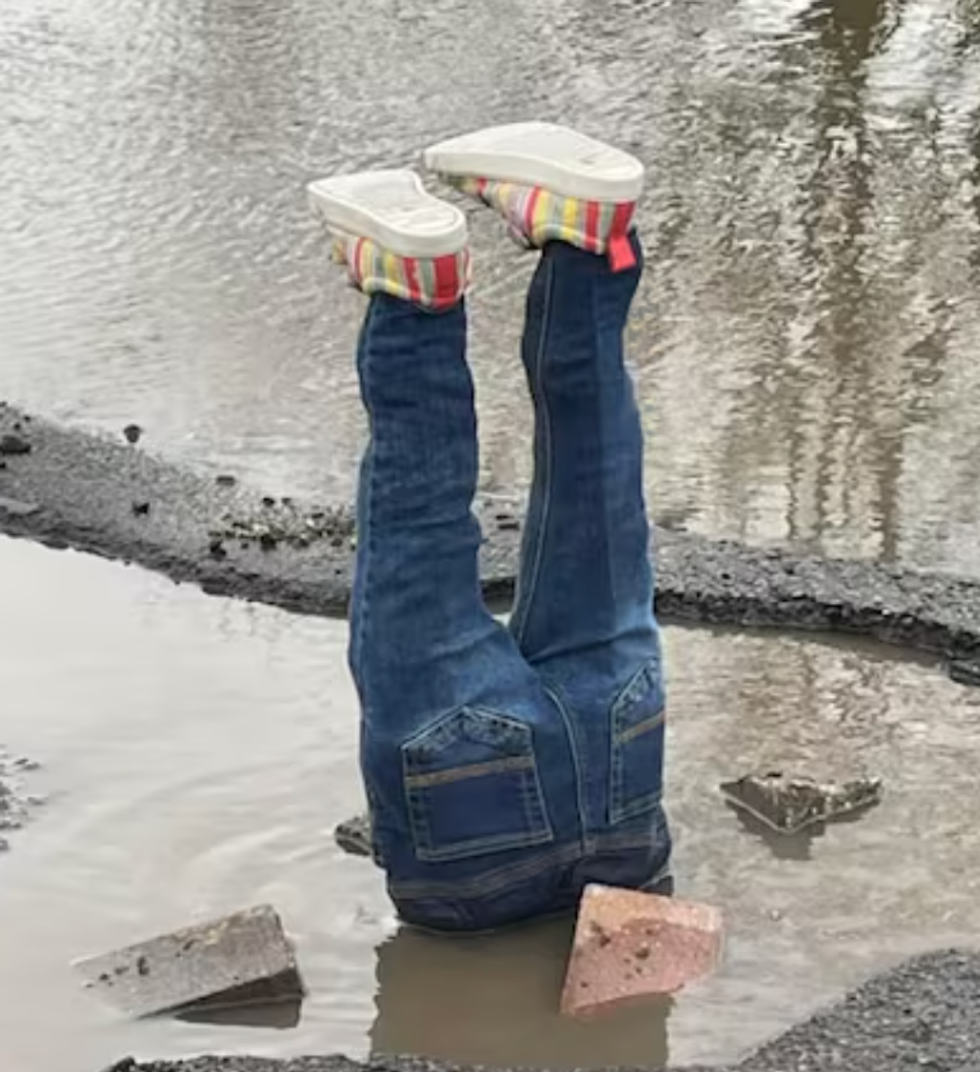 Feet sticking out of a pothole