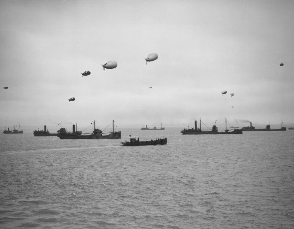 Image Source: A convoy of merchantmen and colliers protected by warships of the Royal Navy and anti aircraft barrage balloons assemble off the North West Coast of England ready to depart. (Photo by Central Press/Hulton Archive/Getty Images)