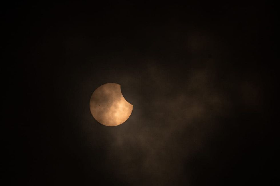 Image Source: A detail of the sun during annular solar eclipse at Planetarium of Bogota on October 14, 2023 in Bogota, Colombia. (Photo by Diego Cuevas/Getty Images)