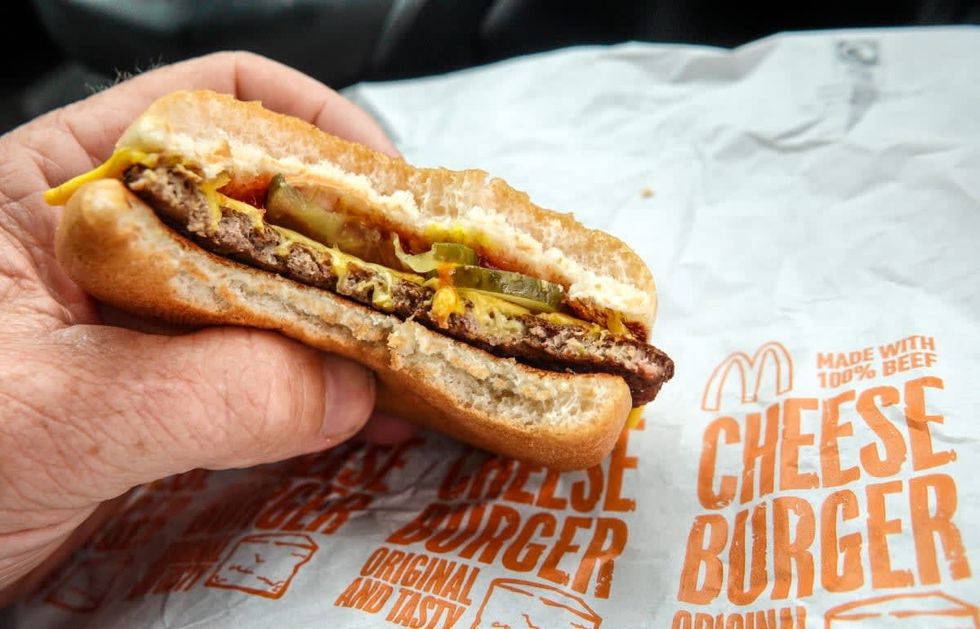 Image Source: A man eats a McDonald's cheeseburger on July 27, 2022 in Bristol, England. (Photo by Matt Cardy/Getty Images)