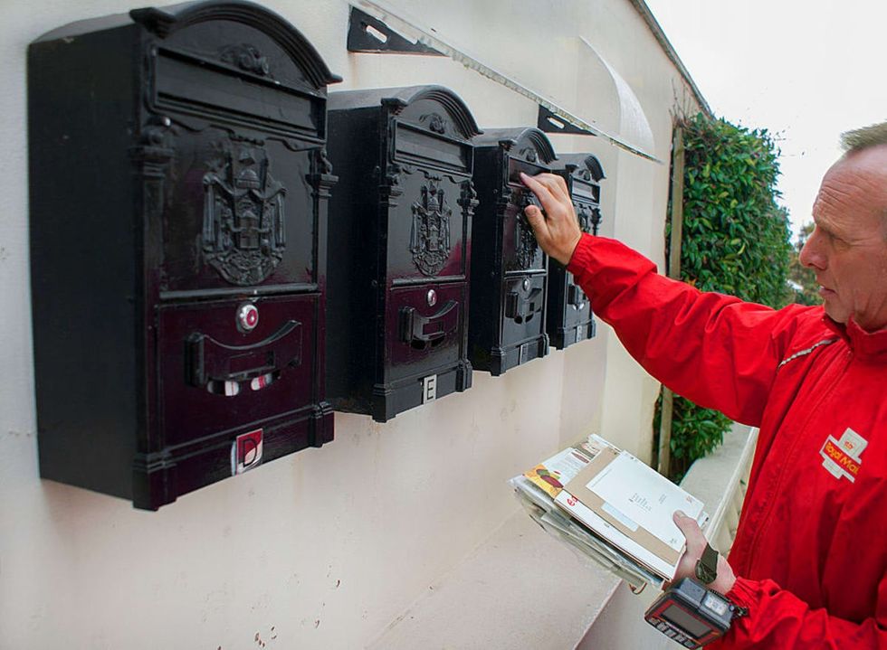 Image source: A Postman delivers mail to letterboxes on a wall in Nottingham,UK.