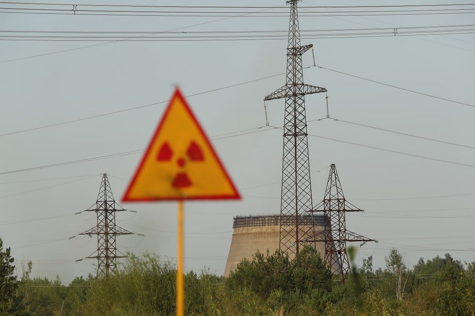 Image Source: A radiation sign stands near electricity pylons and a partially-constructed and abandoned cooling tower inside the exclusion zone near the Chernobyl nuclear power plant on August 19, 2017. (Photo by Sean Gallup/Getty Images)