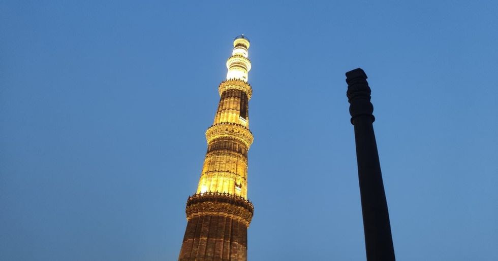 Image Source: A view of the Iron Pillar of Delhi in the Qutab Minar complex at night on February 20, 2022 in New Delhi, India. (Photo by Pallava Bagla/Corbis via Getty Images)