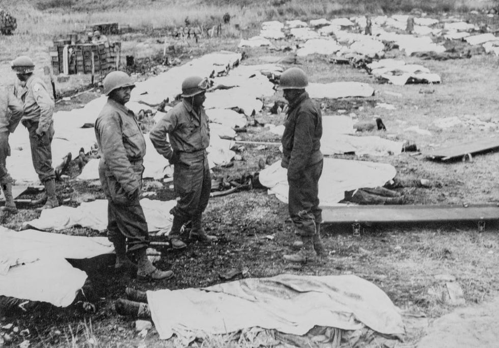 Image Source: African American soldiers with the 603d Quartermaster Corps Graves Registration Company, collect and process the soldiers killed from both the United States Army and German Army for temporary burial at the Omaha Beach Collecting Pointin 1944 on Normandy. (Photo by Wilmott Ragsdale/Pool/Keystone/Hulton Archive/Getty Images).