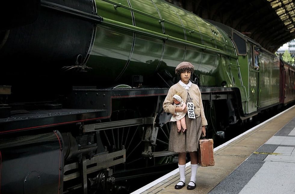 Image source: An actress plays the part of an evacuee child at Liverpool Street railway station on September 4, 2009. A steam train carrying some of the original evacuees re-enacted the original journey. (Photo by Peter Macdiarmid/Getty Images)