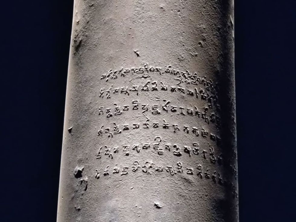 Image Source: Calligraphy written in the ancient Indian language Pali on the Iron Pillar at night on February 20, 2022 in New Delhi, India. (Photo by Pallava Bagla/Corbis via Getty Images)