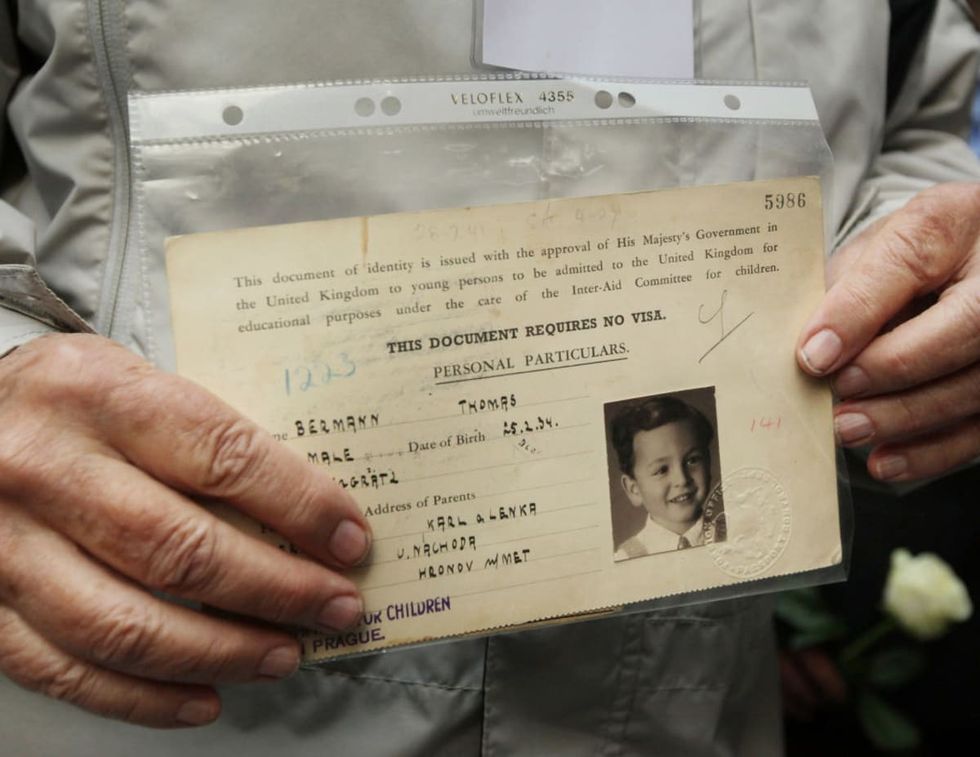 Image source: Evacuee Thomas Bermann holds his original British identity document at Liverpool Street railway station on September 4, 2009 in London, England. (Photo by Peter Macdiarmid/Getty Images)