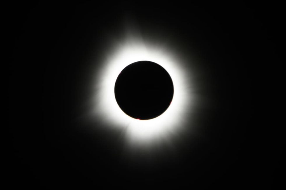 Image Source: he Moon crosses in front of the Sun during a total solar eclipse at Lake Monroe on April 08, 2024 in Indiana, United States. (Photo by Edward M. Pio Roda/Getty Images)