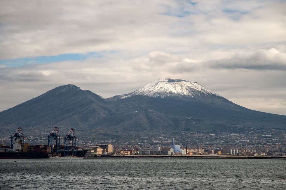 Image Source: Mount Vesuvius is capped with snow as seen from the Maritime Station on March 20, 2021 in Naples, Italy. (Photo by Ivan Romano/Getty Images)