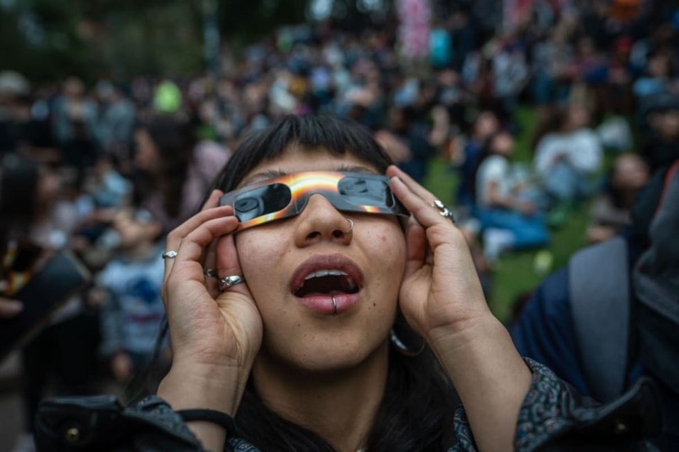 Image source: People surprises to see the eclipse despite the cloudy sky during an annular solar eclipse at Planetarium of Bogota on October 14, 2023 in Bogota, Colombia. (Photo by Diego Cuevas/Getty Images)