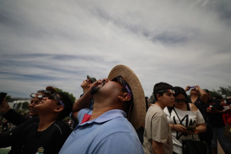 Image Source: People wear glasses to watch the total solar eclipse on April 8, 2024 in Torreon, Mexico (Photo by Antonio Ojeda/Agencia Press South/Getty Images)