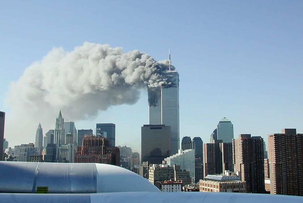 Image source: Smoke pours from the World Trade Center after being hit by two planes on September 11, 2001, in New York City. (Photo by Fabina Sbina/ Hugh Zareasky/Getty Images)