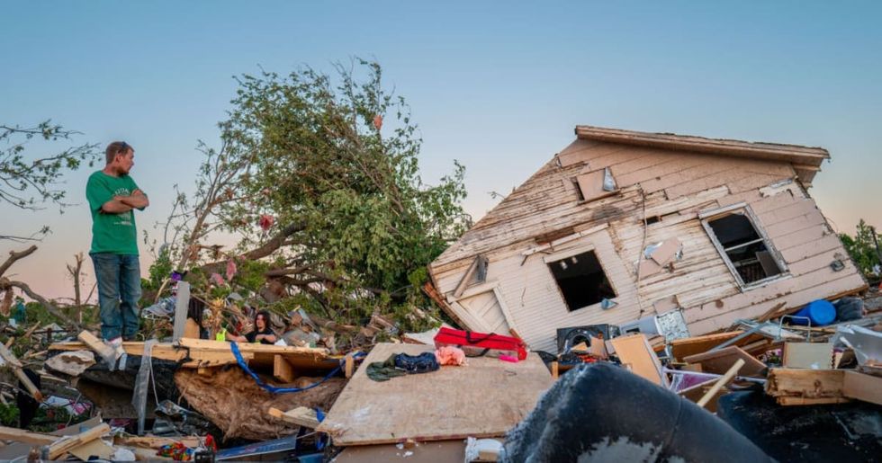 Image Source: The Crowder family surveys their home destroyed by a tornado on May 07, 2024 in Barnsdall, northeast Oklahoma. The EF3 twister that struck claimed one life and destroyed dozens of homes in the community of just over 1,000 people. (Photo by Brandon Bell/Getty Images)