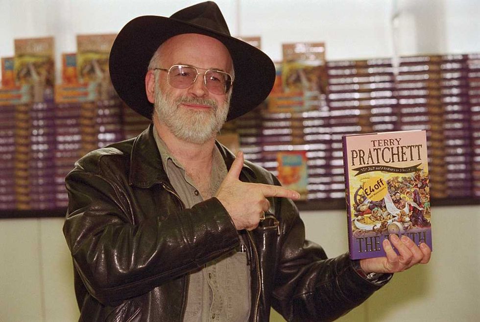 Image Source: Writer Terry Pratchett Pointing to His Book (Photo by Rune Hellestad/CORBIS/Corbis via Getty Images)