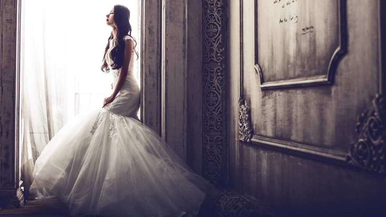 Brother searched football field to find a button for little sister. So she got it sewed on her wedding dress