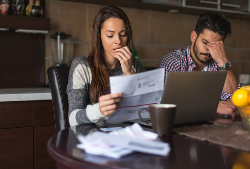 Man and woman looking worriedly at a bill.
