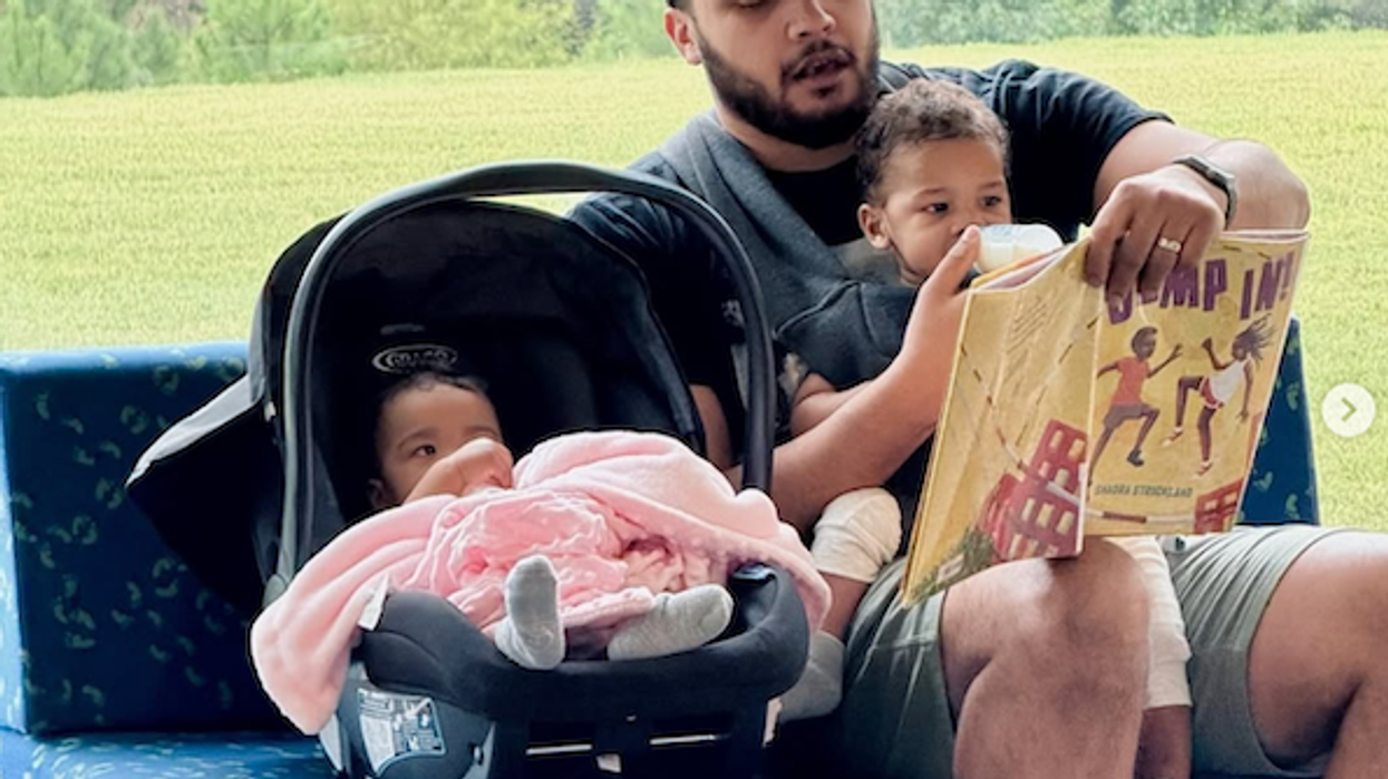 Man reading to his daughter while she sits on his lap