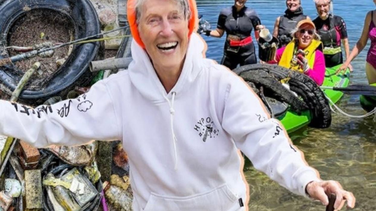 older woman in hoodie smiling with group of women behind her at a lake