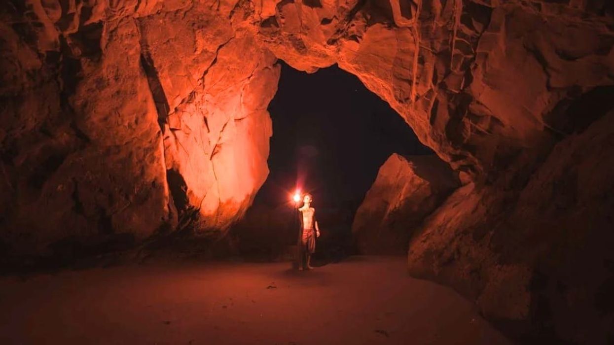 Man descends into a dangerous cave with just a rope and a flashlight to rescue childhood friend
