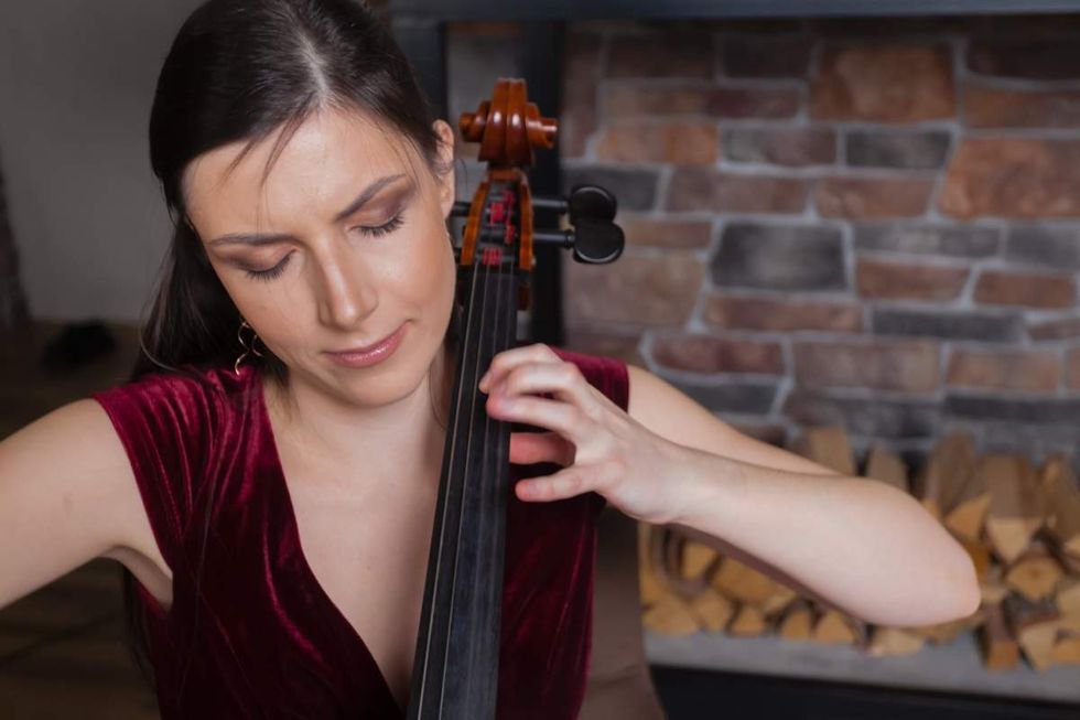 Representative Image Source: A creative cellist in red dress is playing the cello against a brick wall background (Getty Images)