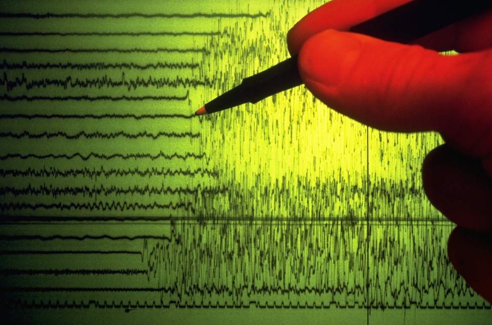 Representative Image Source: A seismographer uses a pen to point out the initial shock waves of an earthquake charted on a seismograph. (Getty Images)