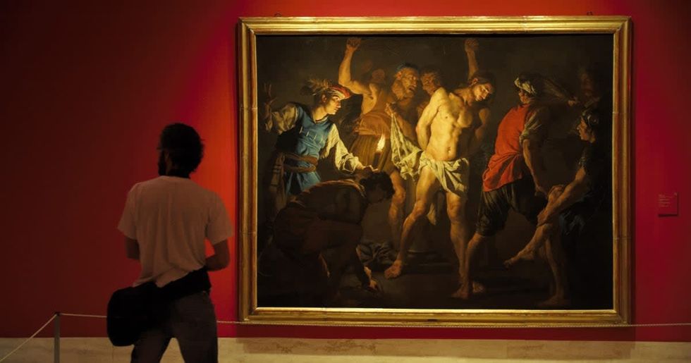 Representative Image Source: A visitor looks at the painting named 'The Flagellation of Christ' by Matthias Stom during the press opening of the exhibition 'Caravaggio and the Painters of the North' at the Thyssen Bornemisza Museum on June 20, 2016 in Madrid, Spain. The exhibition will be open to public from June 21 to September 18, 2016. (Photo by Quim Llenas/Getty Images)