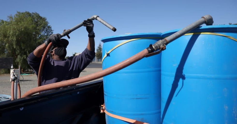 Representative Image Source: Clinton Jackson positions a hose to fill water tanks with recycled water at the Ironhouse Sanitation District residential recycled water fill station on May 20, 2021 in Oakley, California. (Photo by Justin Sullivan/Getty Images)