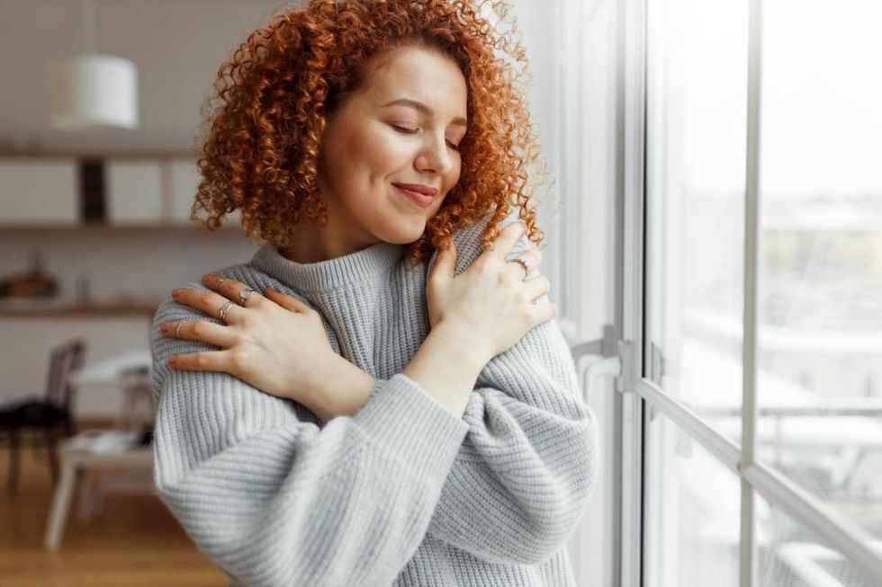 Representative Image Source: Horizontal image of pretty redhead female with closed eyes wearing rings on fingers, hugging herself. (Getty Images)