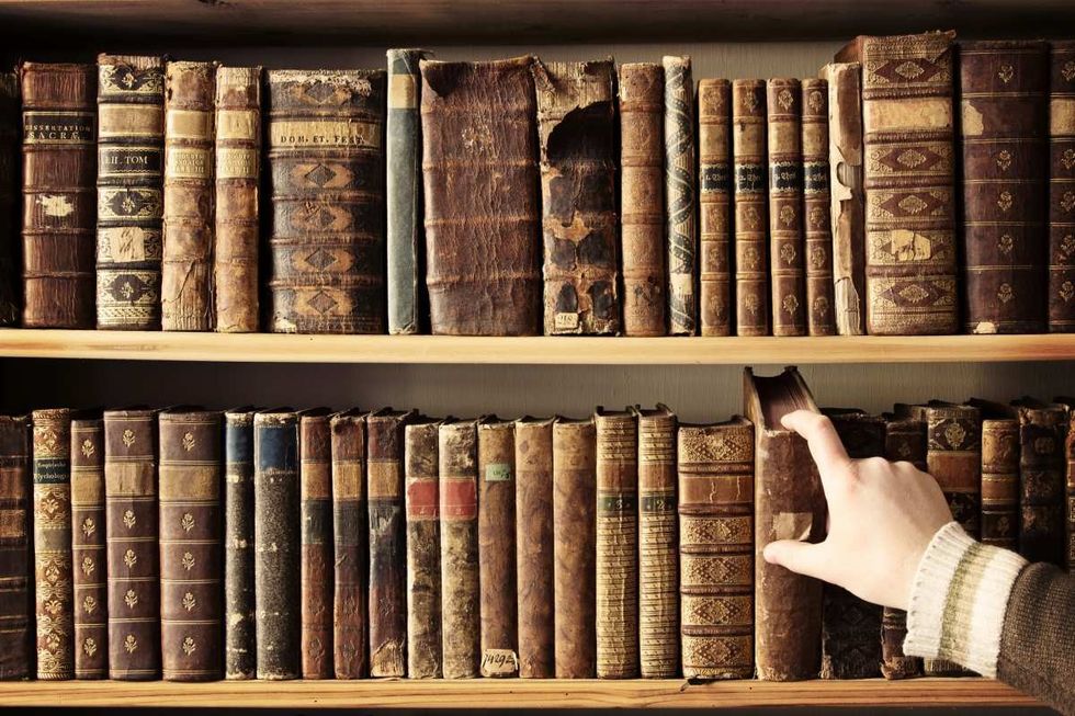 Representative Image Source: Male hand picking a book from a row of antique books. (Getty Images)