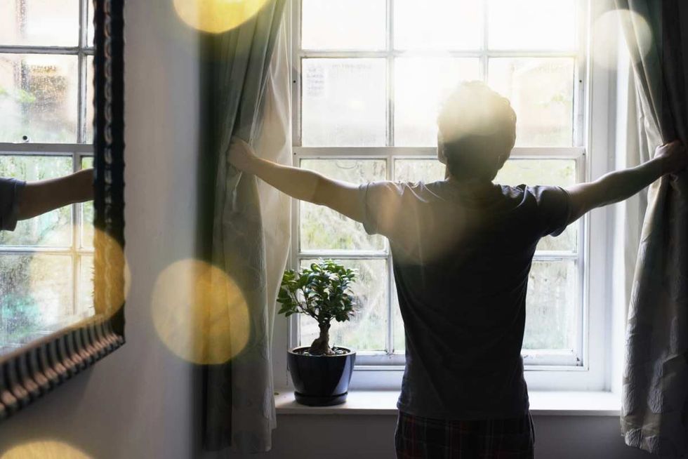 Representative Image Source: Man opening curtains in the morning (Getty Images)