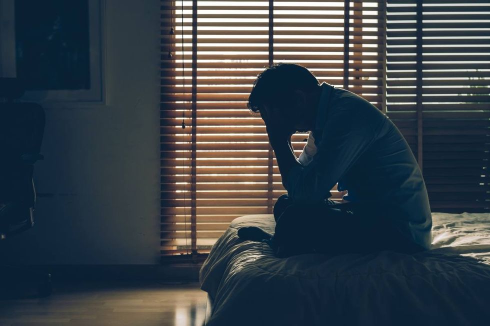 Representative Image Source: Sad businessman sitting head in hands on the bed in the dark bedroom with low light environment, dramatic concept. (Getty Images)