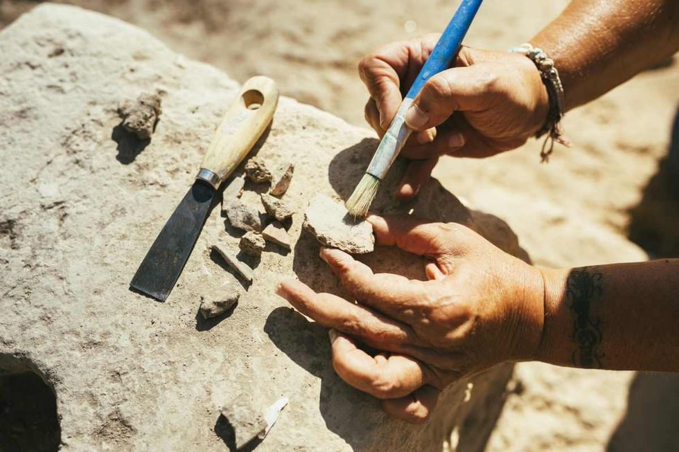 Representative Image Source: Woman's hands using a brush to clean up a piece of ancient pottery on an archaeological site (Getty Images)