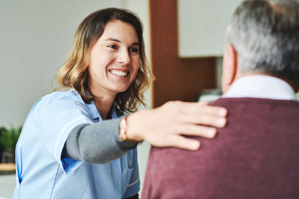 Shot of an attractive young nurse sitting and bonding with her senior patient in his kitchen at home (Representative Image Source: Getty Images | DMP)