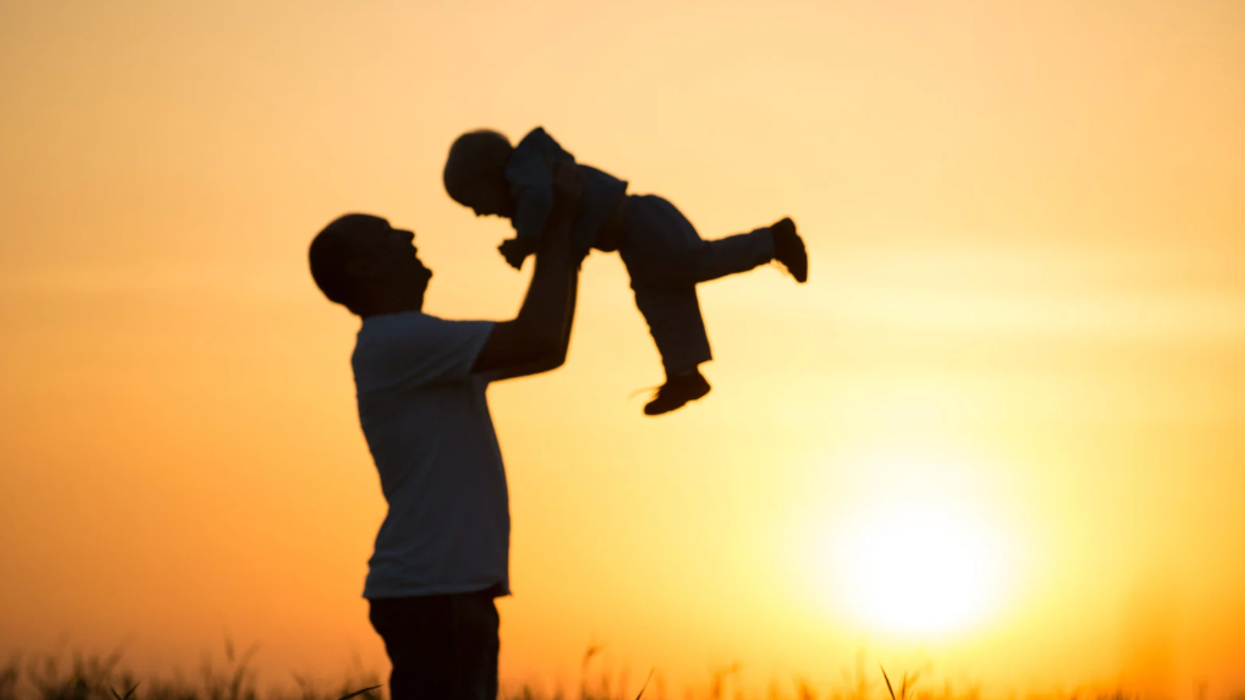 Silhouette of older man with young child
