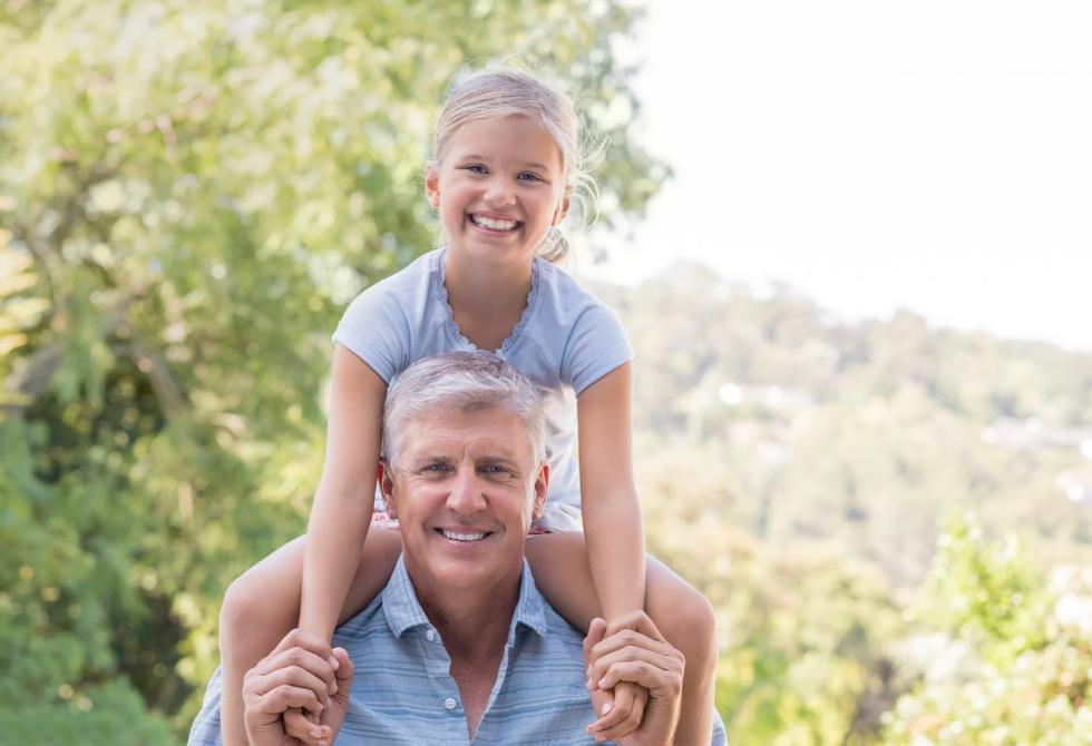 Young girl on older man's shoulders