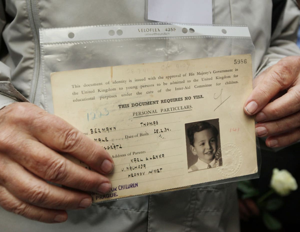 Image source: Evacuee Thomas Bermann holds his original British identity document at Liverpool Street railway station on September 4, 2009 in London, England. (Photo by Peter Macdiarmid/Getty Images)
