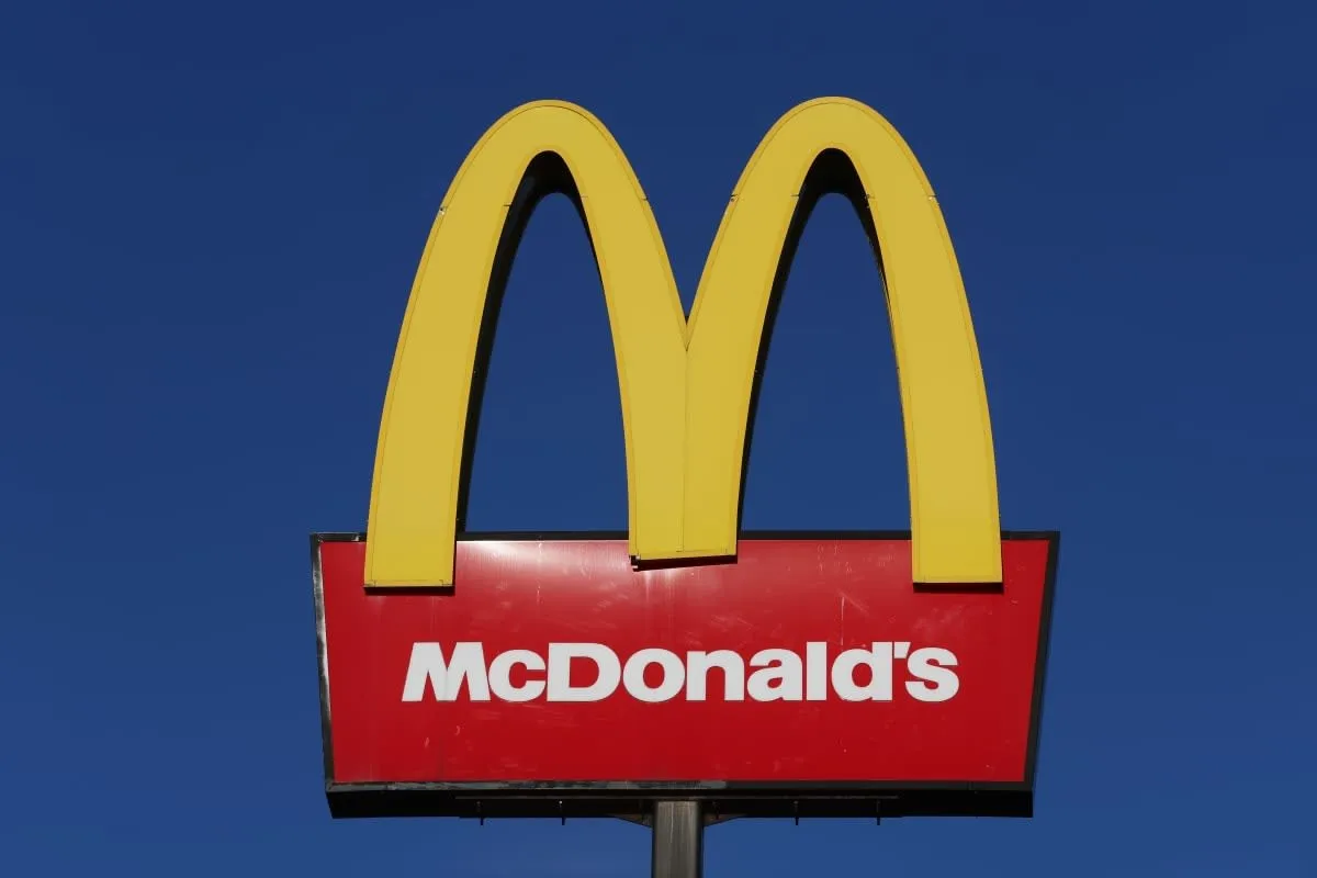 Image Source: The American fast food company, McDonalds logo is displayed outside one of its stores on January 09, 2024 in Stoke-on-Trent, United Kingdom. (Photo by Nathan Stirk/Getty Images)