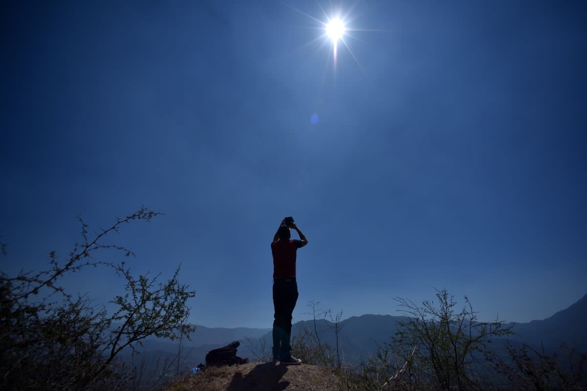 Image Source: A person with glasses watches the total solar eclipse on April 8, 2024 in Colima, Mexico (Photo by Leonardo Montecillo/Agencia Press South/Getty Images)