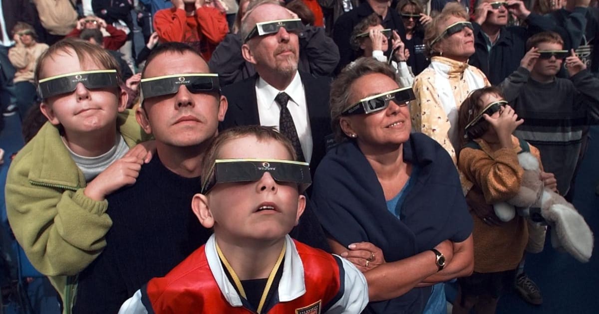 People watch a solar eclipse from the deck of a specially chartered ferry in the English Channel, 11th August 1999. (Photo by Colin Davey/Getty Images)