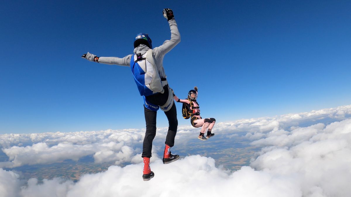 Two people free fall while sky diving.