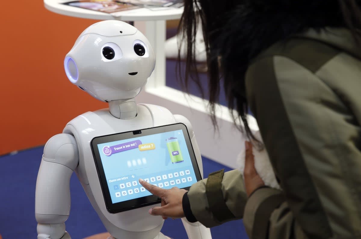 Image Source: A visitor interacts with a Pepper humanoid robot on the SoftBank Group Corp. (Photo by Chesnot/Getty Images)