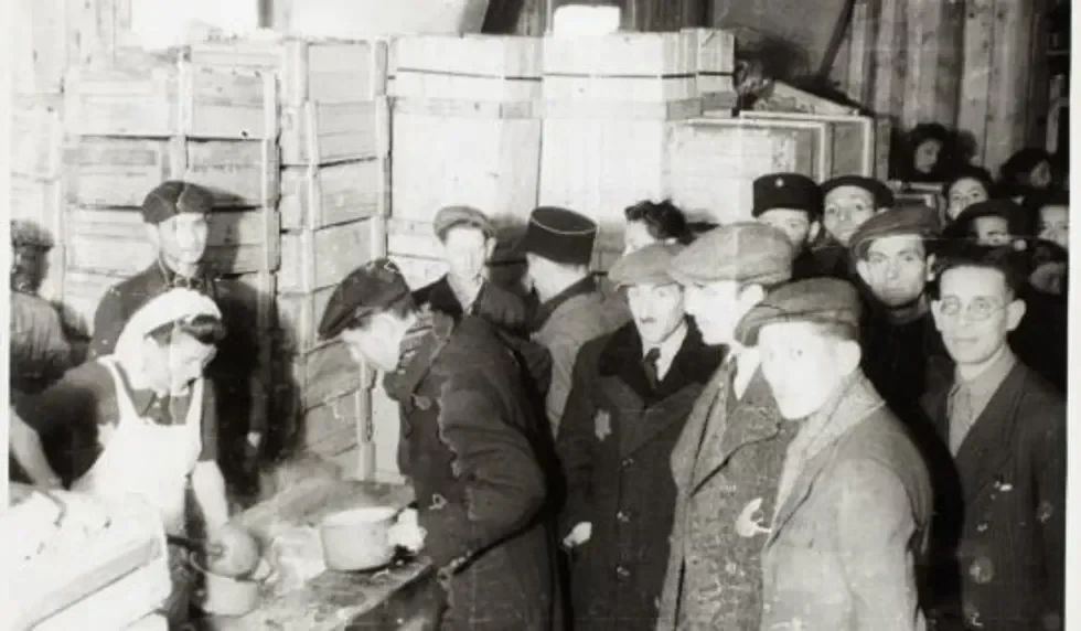 Cook ladling soup into pails for captives.