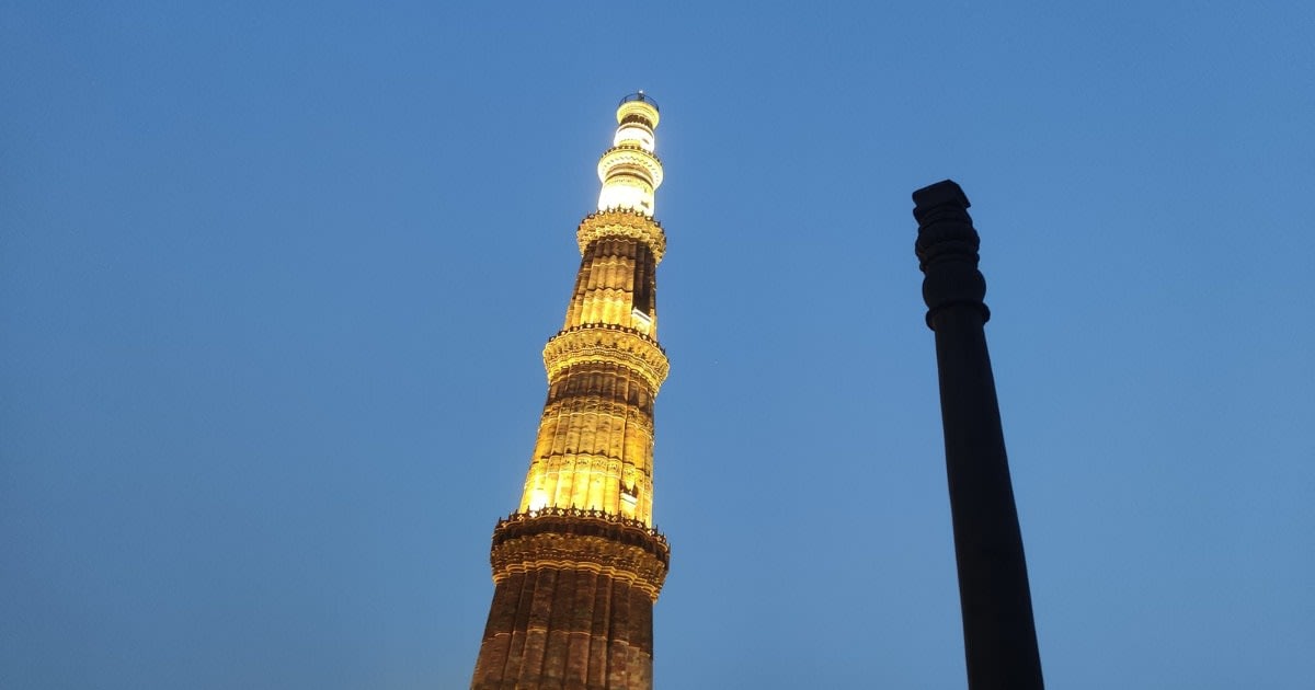 Image Source: A view of the Iron Pillar of Delhi in the Qutab Minar complex at night on February 20, 2022 in New Delhi, India. (Photo by Pallava Bagla/Corbis via Getty Images)
