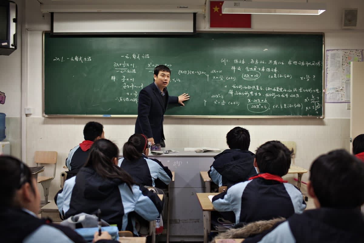 Image Source:  Math teacher Zhang Yinrui teaches a class in Shanghai Jiao Tong University No.2 Affiliated Middle School February 28, 2011 in China. (Photo by David Hogsholt/Getty Images)